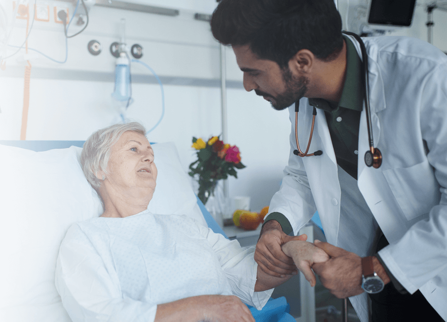 a physician talking to a patient in her hospital bed 